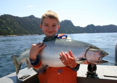 King Salmon fishing on Prince of Wales Island. Adventure Alaska Southeast fishing charters. Little boy holding giant King Salmon