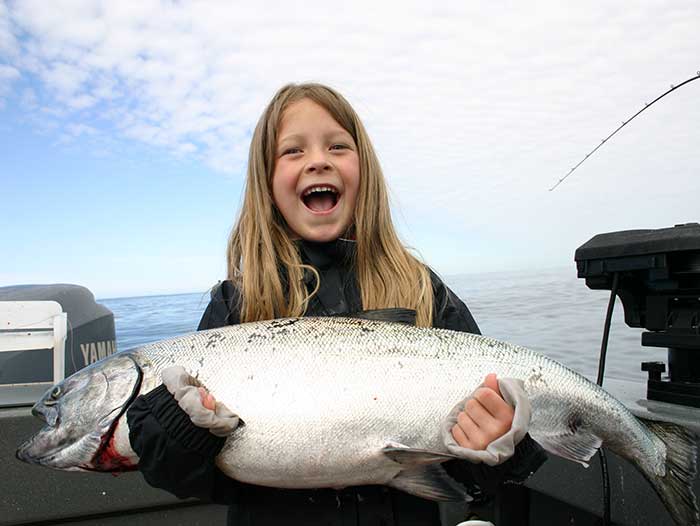 King Salmon fishing on Prince of Wales Island. Adventure Alaska Southeast fishing charters. Little girl holding giant King Salmon