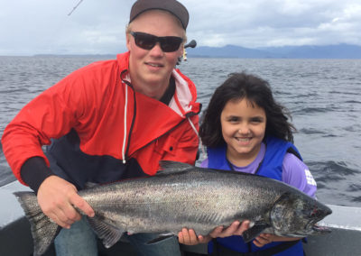 Fishing charters for King Salmon on Prince of Wales Island. Adventure Alaska fishing and hunting vacation packages in Thorne Bay on Prince of Wales Island. Young girl and her catch of a king salmon.