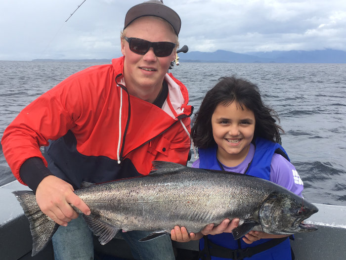 Fishing charters for King Salmon on Prince of Wales Island. Adventure Alaska fishing and hunting vacation packages in Thorne Bay on Prince of Wales Island. Young girl and her catch of a king salmon.