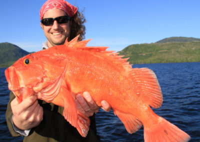 Adventure Alaska fishing lodge accommodations. Man with his catch of a yelloweye rockfish.