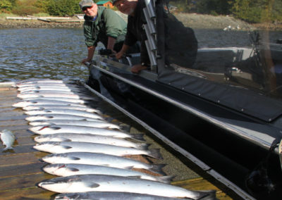 Men with their catch of salmon beside their upgrade rental boat from Adventure Alaska Southeast.